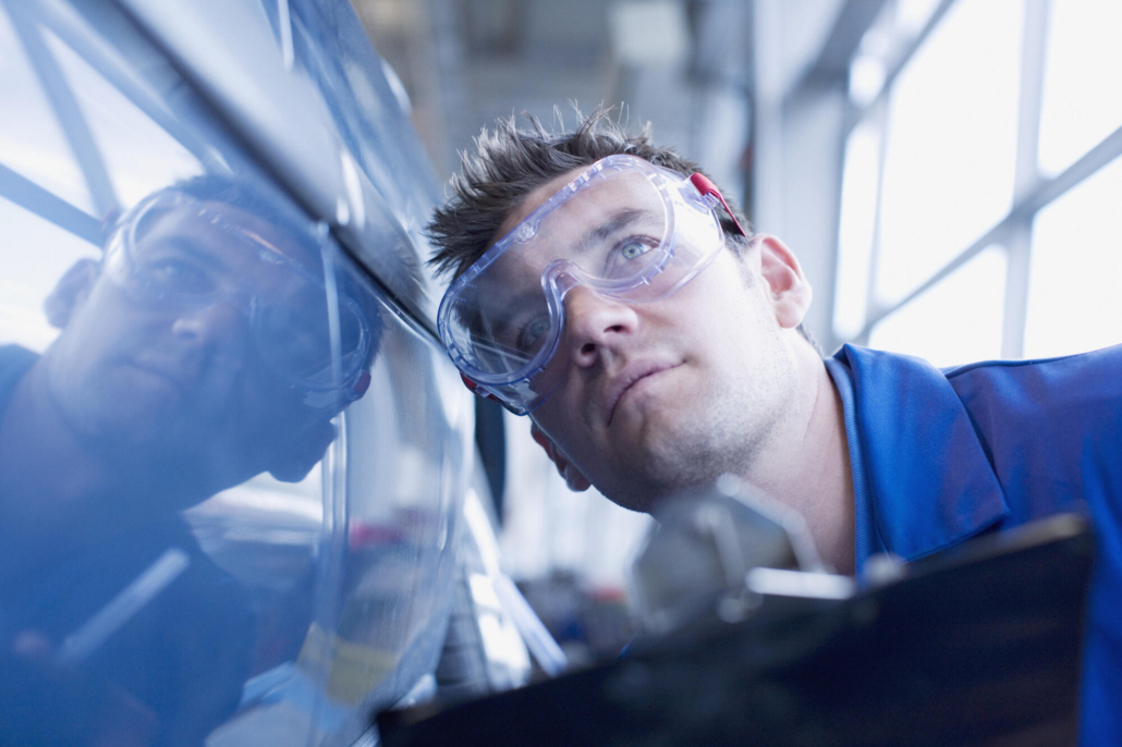 technician inspecting car paint finish